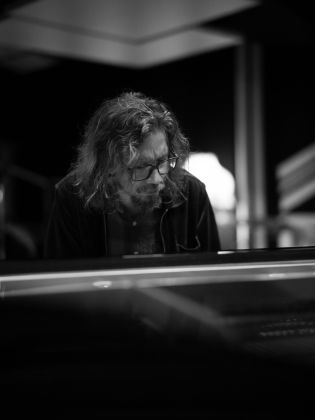 Svartvitt foto på man som spelar piano
