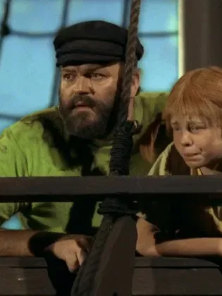 En rödhårig flicka står med en man på ett skepp.