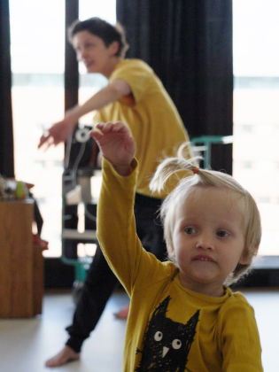 Barn och vuxna dansar tillsammans. 