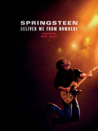 En man spelar elgitarr i strålkastarljus.
