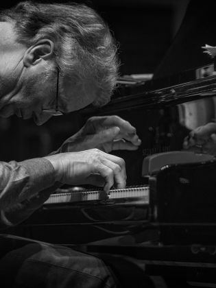 En pianist som lutar sig över tangenterna
