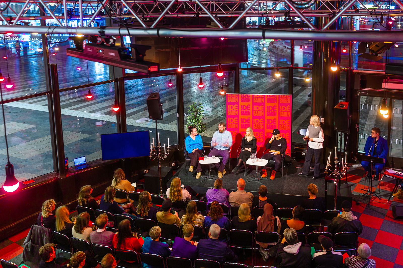 Evenemang i Lilla studion med fem personer i en panel på scen och publik i bänkrader. 