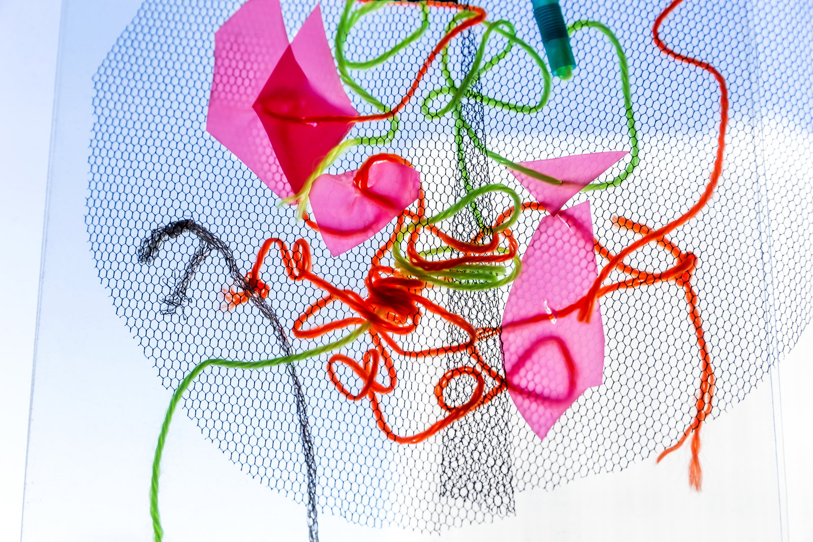 Ett mönster av trådar, tygbitar och pappersbitar. 