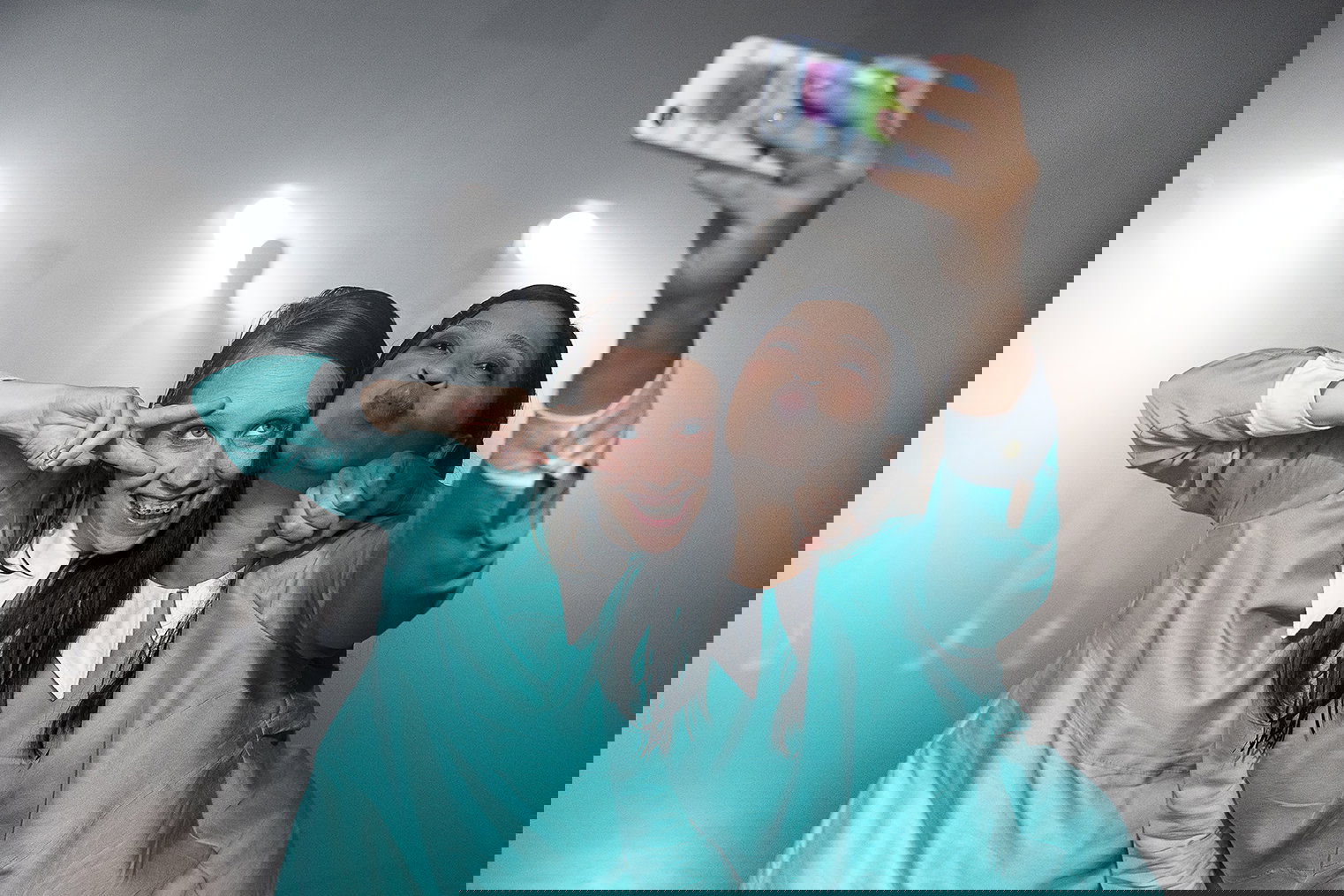 Två personer grimaserar och tar en selfie tillsammans.  