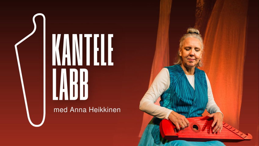 Kvinna i turkos klänning sitter på en scen och spelar ett rött stränginstrument, med orange tygstycken i bakgrunden.