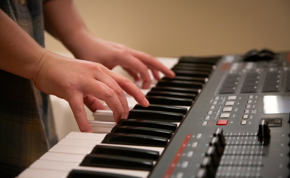 Händer som spelar på en synth