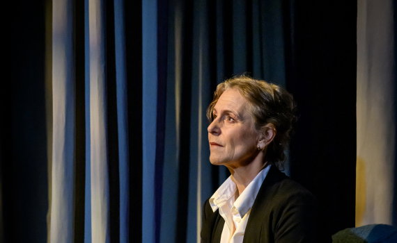 Helen Sjöholm som Margareta Hellstedt sitter blickandes upp mot ljuset.