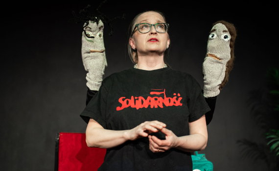 Gertrud Lartsson med två strumpdockor på varsin sida.