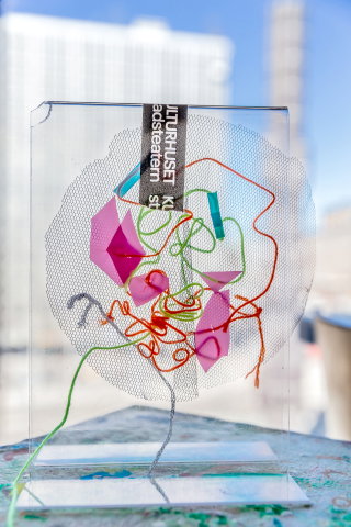 Ett mönster av trådar, tygbitar och pappersbitar. 