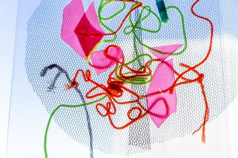 Ett mönster av trådar, tygbitar och pappersbitar. 