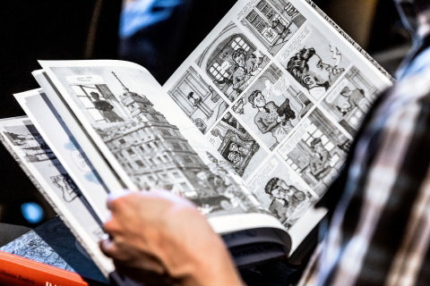 En person läser i en seriebok. 