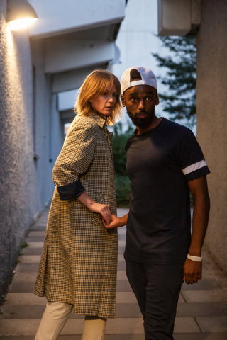 Två personer möts i en gränd och tar varandra i handen