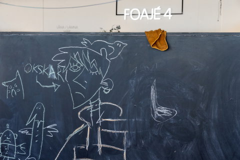 Svart tavla med kritteckningar av figurer och texten "OKSKAR", i rum märkt "Foajé 4".