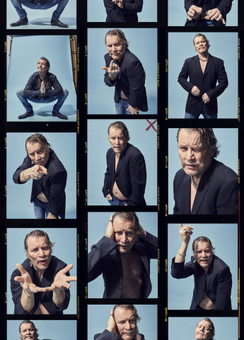 Medelålders man med grått hår och mustasch i svart kavaj och jeans poserar och gestikulerar mot blå bakgrund, collage.