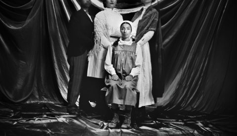 Svartvit bild i äldre stil av familj där en ung kvinna ser chockad ut.