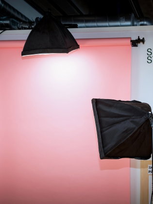 En rosa skärm med tre spotlights runt. 