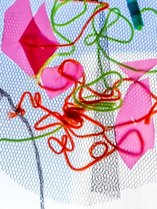 Ett mönster av trådar, tygbitar och pappersbitar. 