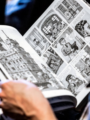 En person läser i en seriebok. 