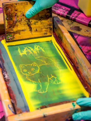 En person jobbar med screentryck. 