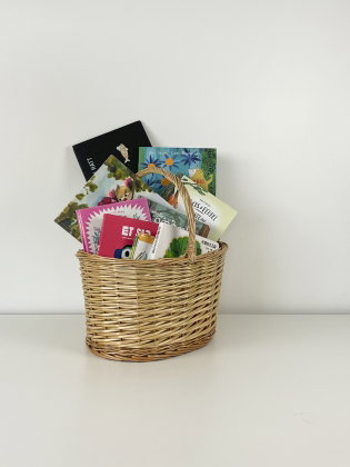 En korg fylld med barnböcker på olika språk. 