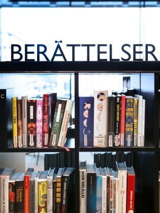 En bokhylla med böcker i på ett bibliotek. 