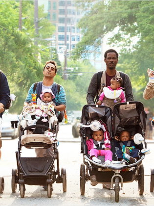 Fyra män med bäbisar drar barnvagnar.