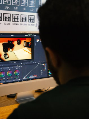 Person redigerar ett foto med färgkontroll på en datorskärm i ett redigeringsprogram.