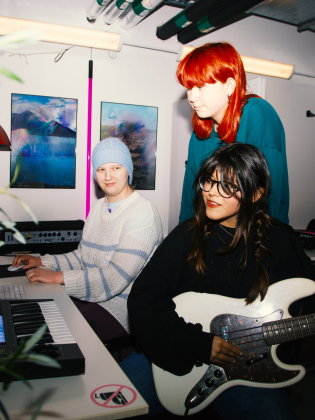 Tre ungdomar spelar instrument och spelar in egen musik i Lavas studio