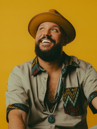 En man i hatt mot gul bakgrund