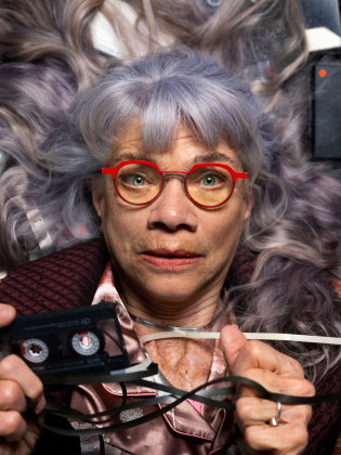 Skådespelaren Iwa Boman ligger på en bädd av kassettband 