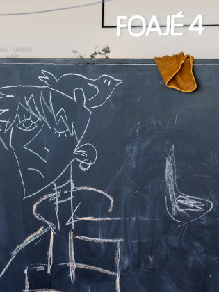 Svart tavla med kritteckningar av figurer och texten "OKSKAR", i rum märkt "Foajé 4".