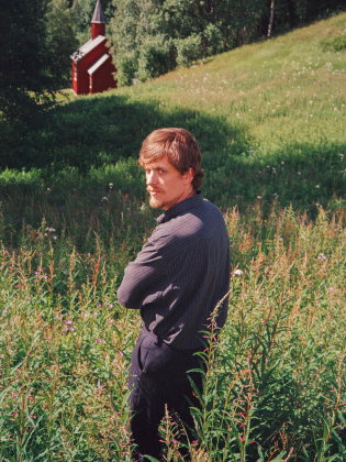 En man står på en blommig äng