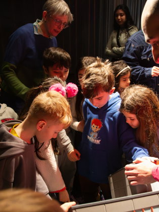 Barn som tittar på en modell av Kulturhuset Stadsteatern Skärholmen