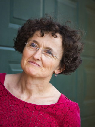 Marie-Hélène Lafon lutar lätt mot bildens kant i ett naturligt porträtt där det öppna uttrycket och den starka färgen i klädseln ger liv åt bilden.